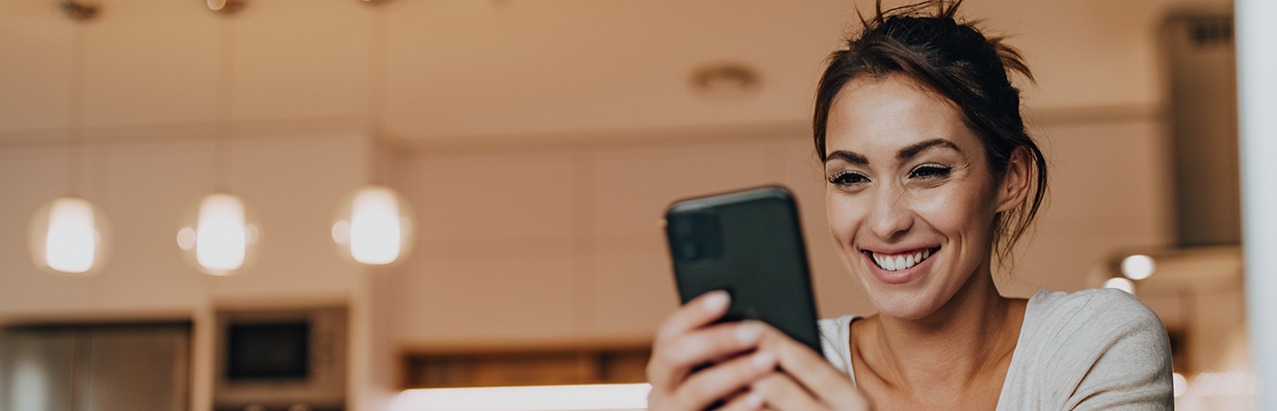 Woman at home looking at mobile phone