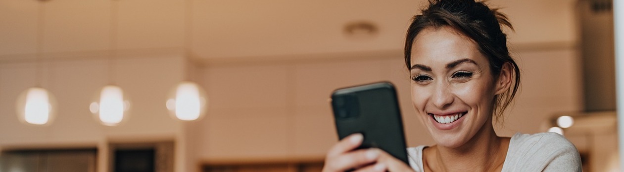 Woman at home looking at mobile phone