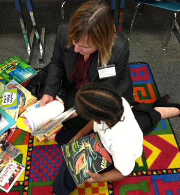 Lady reading with a child in classroom