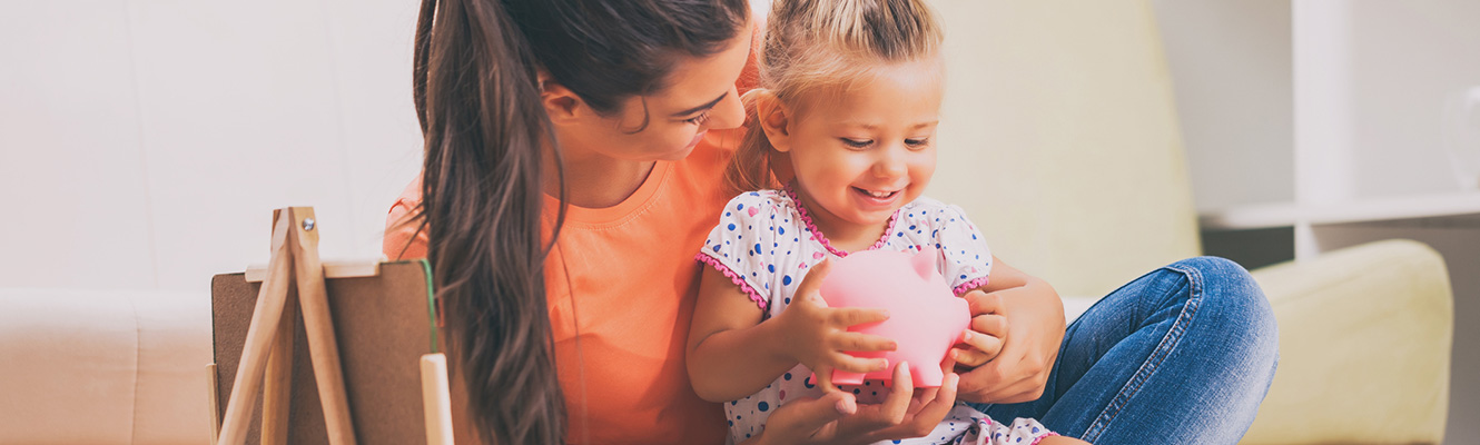 Mother and daughter with a piggy bank