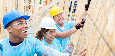 Two kids and a man at a construction site