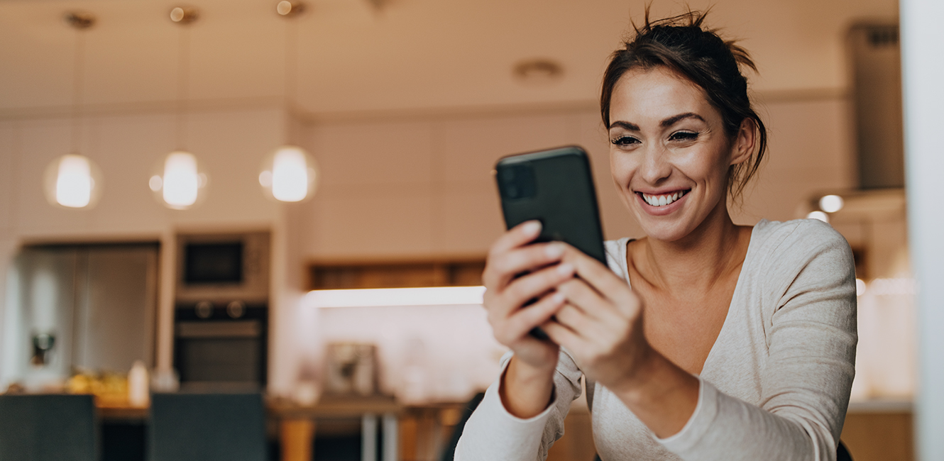 Woman at home looking at mobile phone