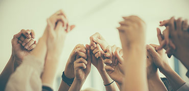 Group of people joining hands in celebration